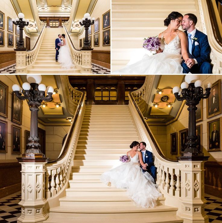 A Bride And Groom Pose For A Photo On The Stairs At Their Wedding Reception In Front Of An