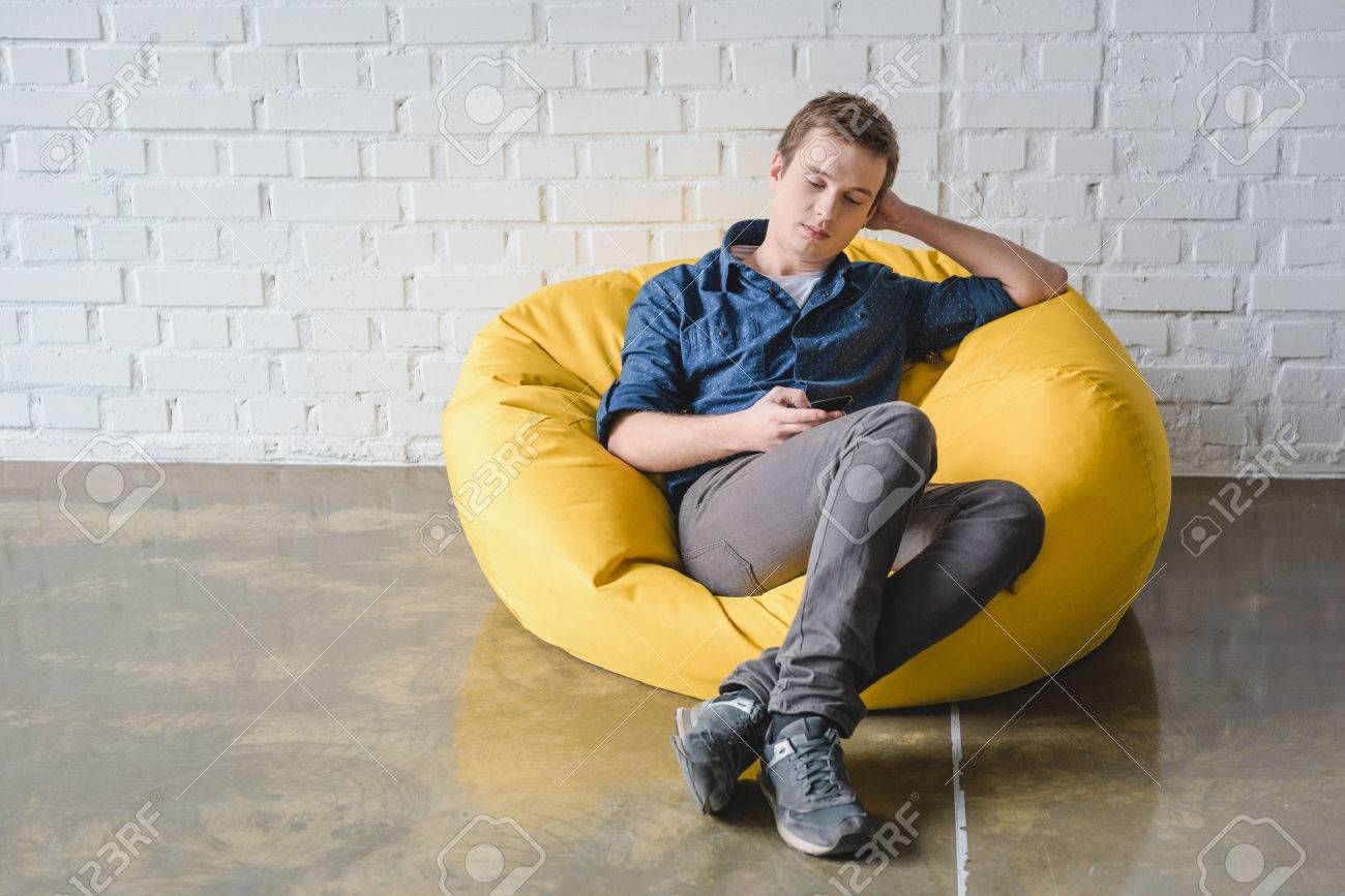 People Sitting On Bean Bag Chairs In Front Of A Projector Screen At An